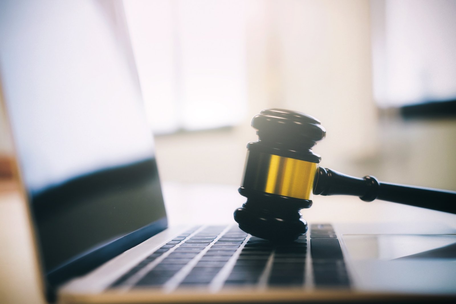 A gavel resting on a laptop, representing traffic court files
